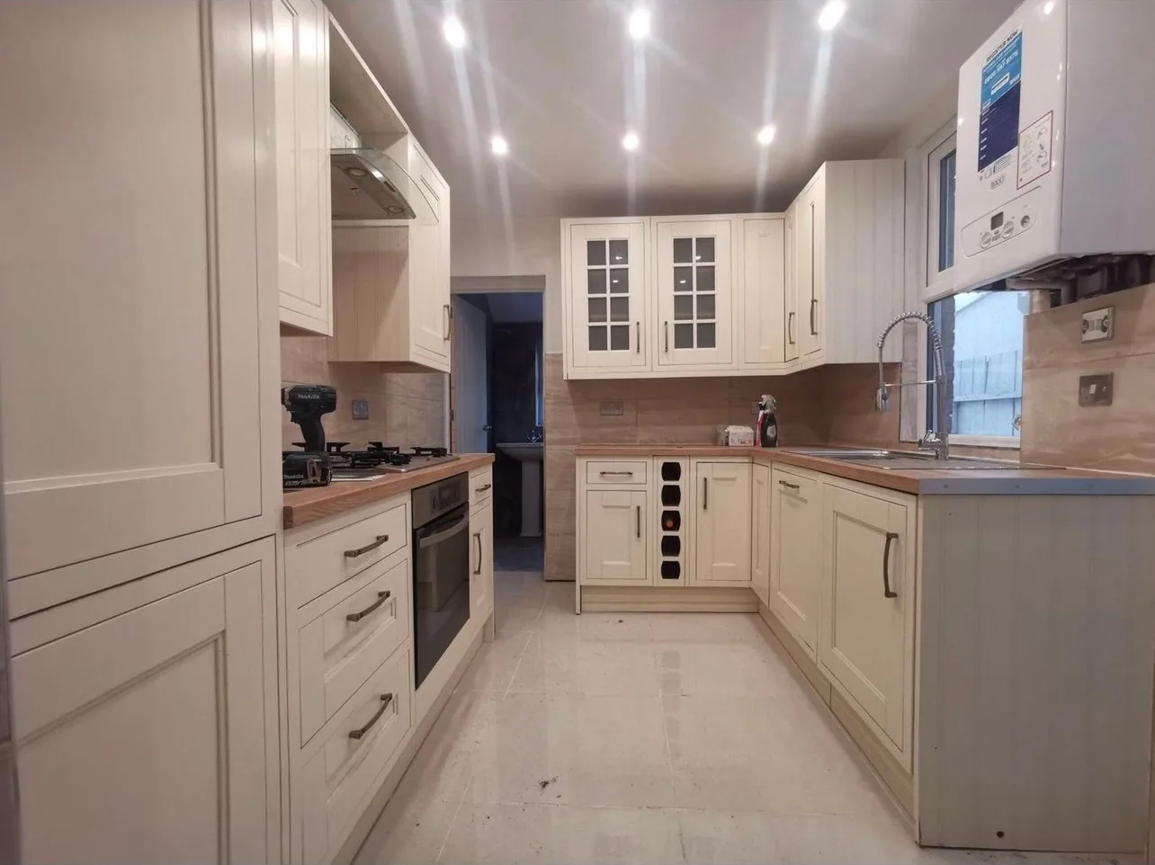 A refitted kitchen in a Bedford terrace with a wall mounted combi boiler and its controller above the worktop