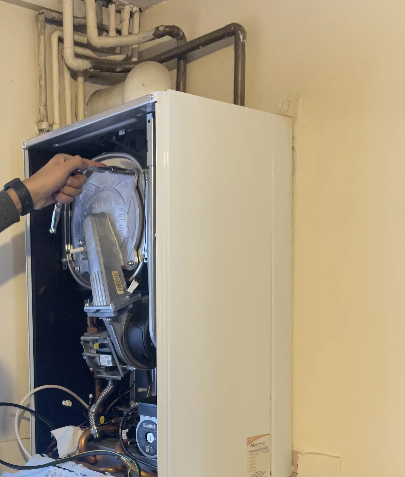 A boiler with the front casing removed during an annual service.