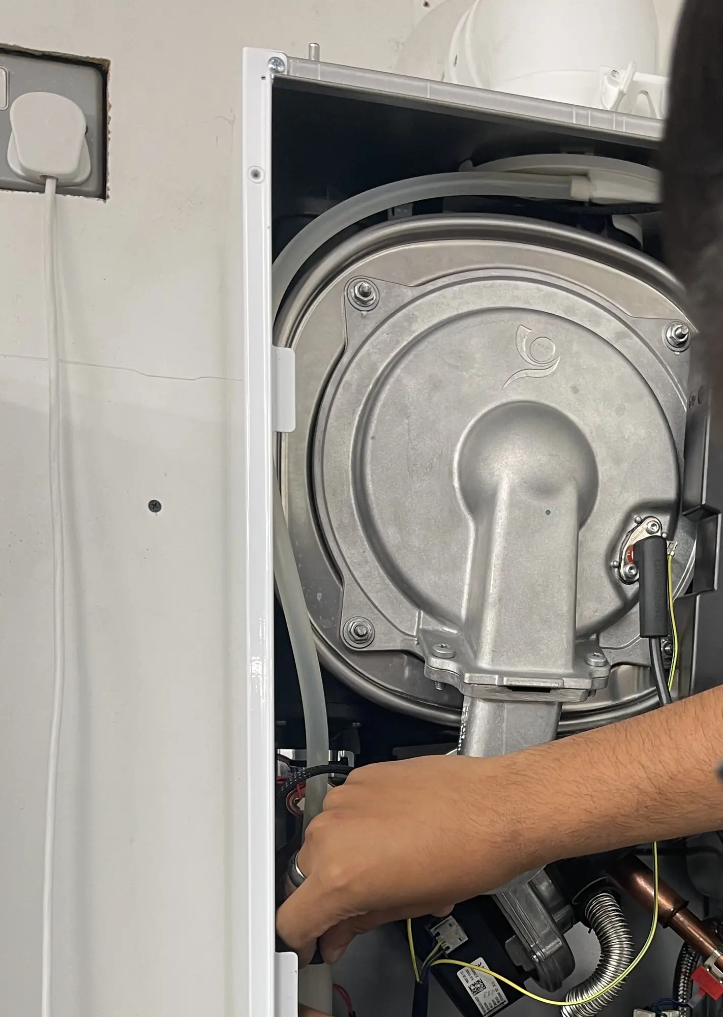 The sealed combustion chamber and fan inside a boiler opened up for a heating repair.