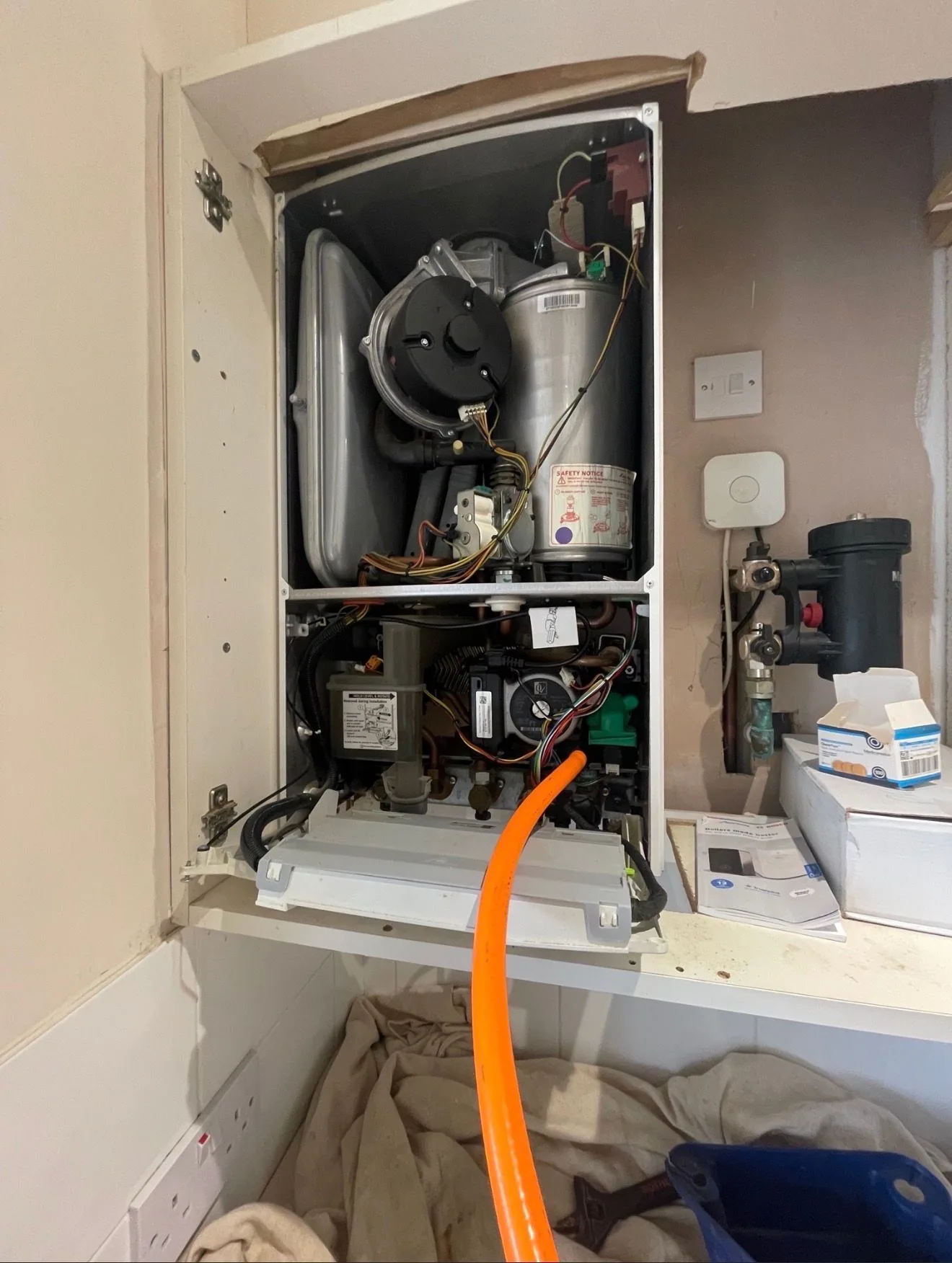 A boiler opened up with the internal components exposed during a heating repair.