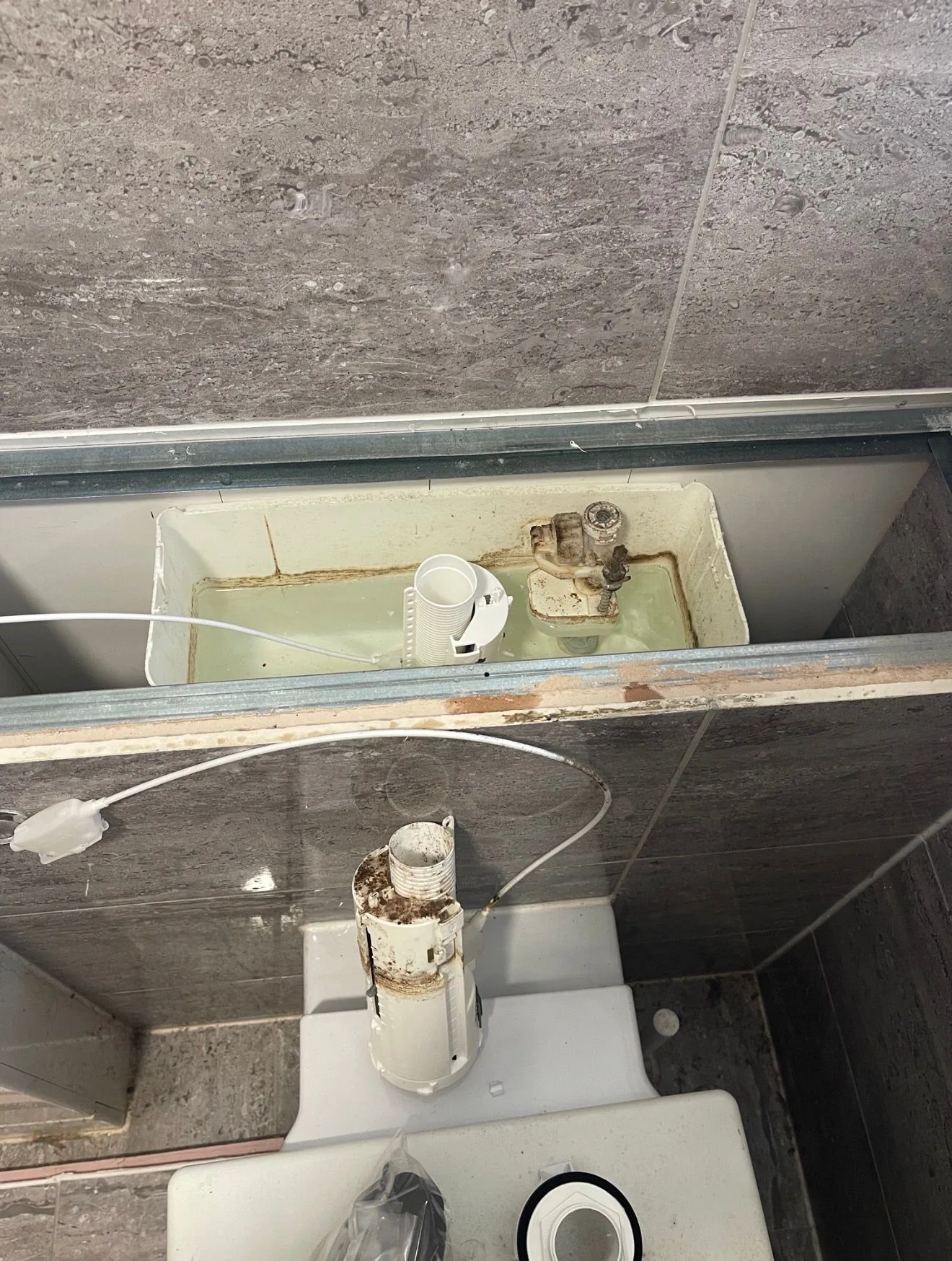A concealed cistern frame opened up to reach the fill valve during a toilet repair.